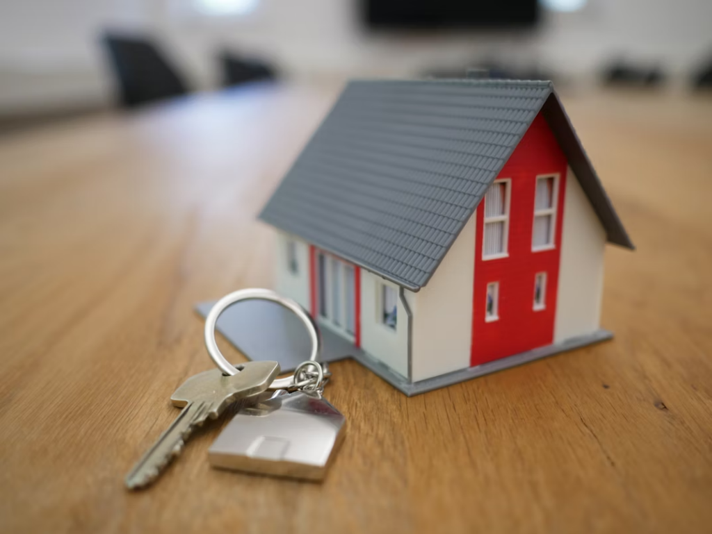 White and red wooden miniature house on a wooden table.